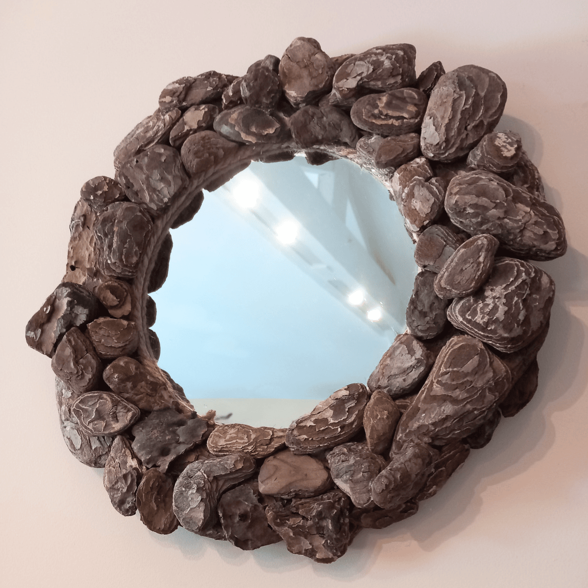 miroir rond fait avec des écorces de bois flotté
