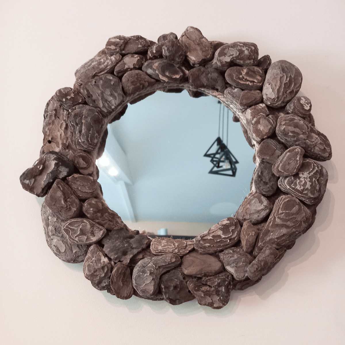 miroir rond fait avec des écorces de bois flotté